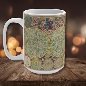 May include: White ceramic mug featuring a vintage celestial map design. The map is in shades of green, yellow, and blue, with detailed illustrations and the text "PLANISPHAERIUM COELSTE". The mug has a large handle and is set against a blurred background.