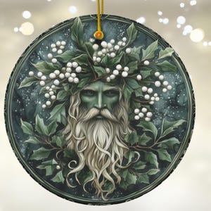 May include: A round ceramic ornament with a green and white design. The ornament features a man's face with a long white beard and a crown of green leaves and white berries. The background is a dark blue with white speckles.