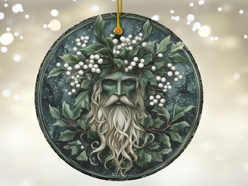 May include: A round ceramic ornament with a green and white design. The ornament features a man's face with a long white beard and a crown of green leaves and white berries. The background is a dark blue with white speckles.