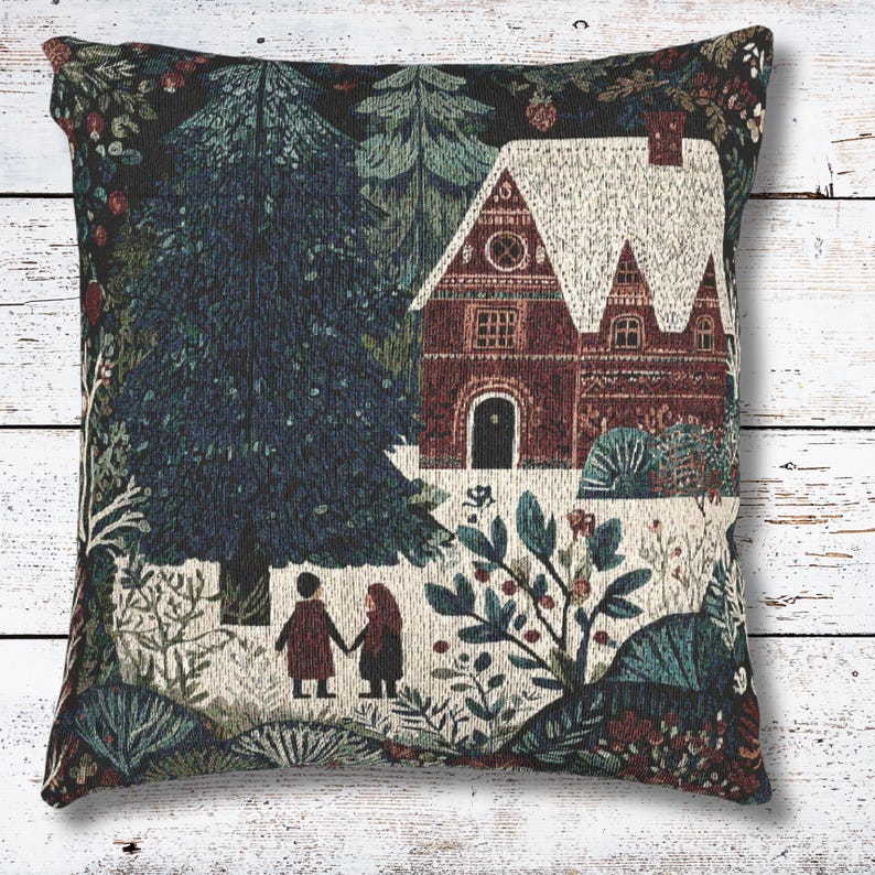 May include: Square decorative pillow with a tapestry design featuring a winter scene. The image shows a house with a snow-covered roof, trees, and two figures holding hands. The color palette includes shades of blue, green, and brown.