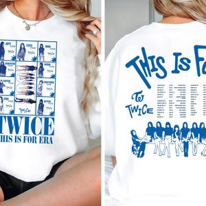 May include: White sweatshirt featuring a blue graphic with the text "TWICE THIS IS FOR ERA" on the front and a tour design on the back. The design includes images of the band members and tour dates.