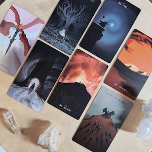 Może przedstawiać: Zestaw kart tarota z r&oacute;żnymi ilustracjami i tytułami, w tym "Four of Swords", "The Fool" i "The World". Karty ułożone są na jasnej powierzchni, z kryształami wok&oacute;ł.