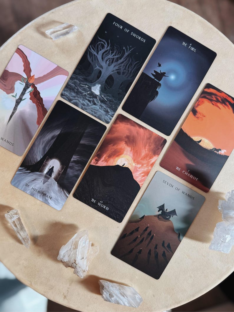 Może przedstawiać: Zestaw kart tarota z r&oacute;żnymi ilustracjami i tytułami, w tym "Four of Swords", "The Fool" i "The World". Karty ułożone są na jasnej powierzchni, z kryształami wok&oacute;ł.