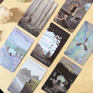 Może przedstawiać: Zestaw kart tarota z ilustracjami o tematyce przyrodniczej i fantasy. Karty wyświetlają tytuły takie jak "Page of Pentacles", "Queen of Pentacles" i "Eight of Pentacles". Karty są ułożone na jasnobrązowej powierzchni.