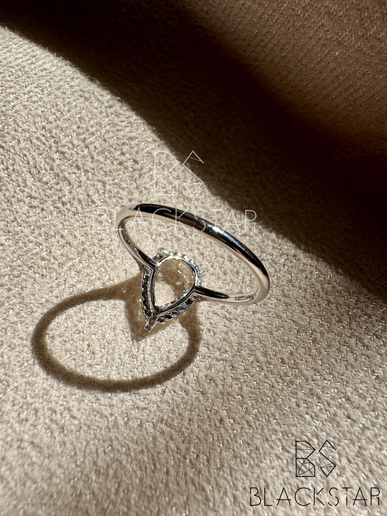 Back underside view of a pear shaped lab grown diamond engagement ring showcasing the elegant open gallery design and secure prong setting. The pear cut diamond is framed with a delicate halo, allowing maximum light to enhance brilliance and fire. Crafted in polished white gold, this ring reflects refined craftsmanship, ethical sourcing, and timeless luxury, perfect for customers searching pear lab diamond engagement rings, sustainable bridal jewelry, and fine handmade diamond rings.