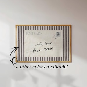 May include: A rectangular framed wall art piece featuring a vintage postcard design with the text "POST CARD" and "with love from texas" written in black script. The print is bordered by a pattern of vertical dark gray and white stripes.