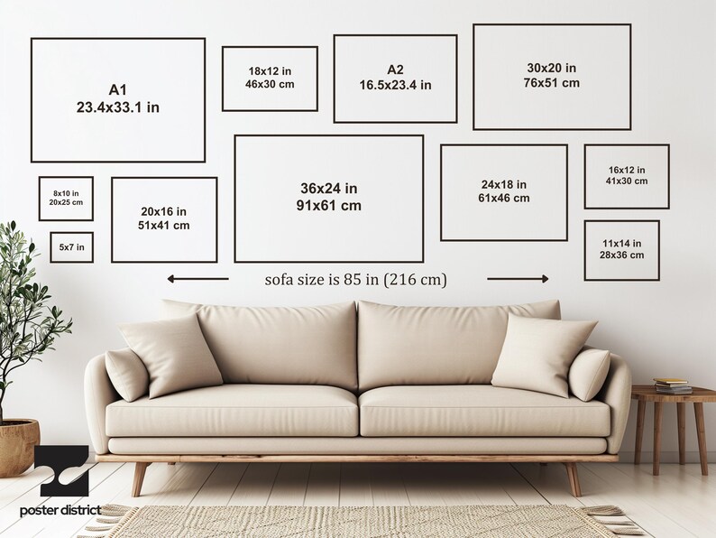 May include: A beige sofa measuring 85 inches in width positioned below a wall display of eleven empty black rectangular frames. Each frame features printed text indicating various dimensions in inches and centimeters, such as A1, 36x24, and 5x7.