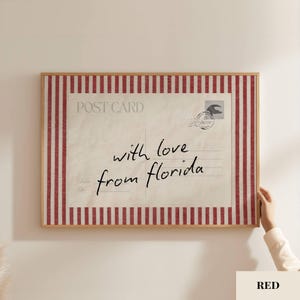May include: A rectangular wall art print featuring a vintage postcard design with a cream-colored background and red vertical stripes along the border. The text reads POST CARD and with love from florida, accompanied by a circular postmark stamp.