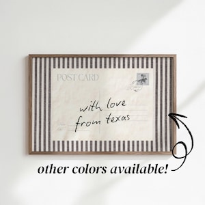 May include: A rectangular framed print featuring a vintage-style postcard design with the text "POST CARD" and "with love from texas" in black script. The postcard is centered on a background of vertical black and white stripes within a wooden frame.