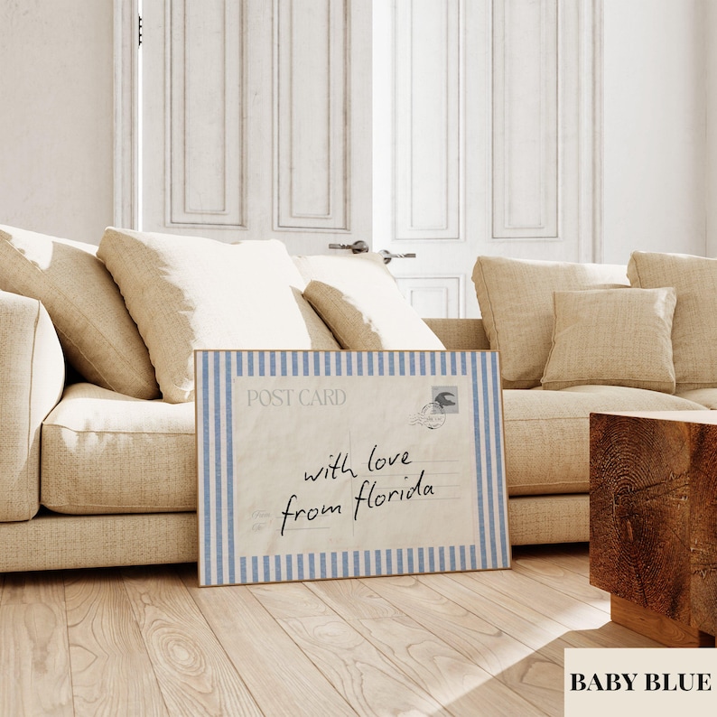 May include: A rectangular wall art print featuring a vintage postcard design with a light blue and white vertical striped border. The center displays the text "POST CARD" and the handwritten script "with love from florida" in black ink.