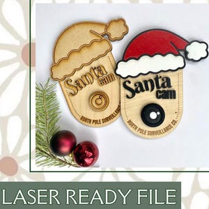 以下が含まれることがあります： サンタの帽子をかぶった木製のサンタカメラの看板2つ。看板には「サンタカメラ」と「北極監視会社」と書かれている