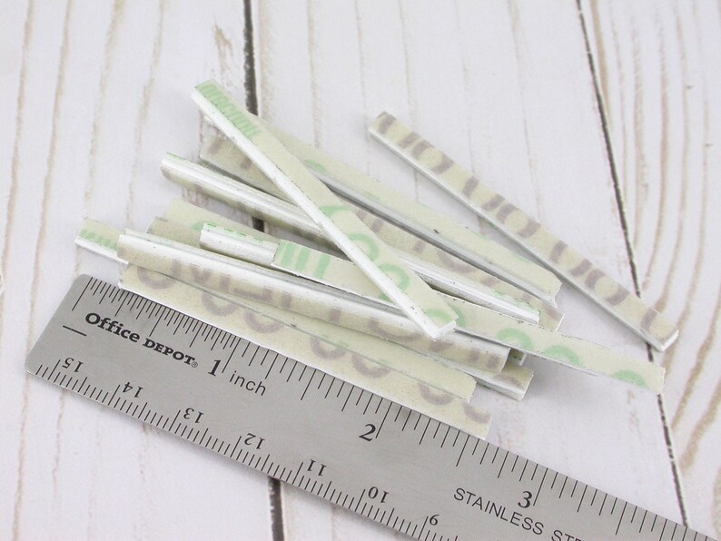 May include: A collection of rectangular, patterned stickers with a ruler that reads "Office DEPOT 1 inch". The stickers have a light green and gray design. The ruler is stainless steel.
