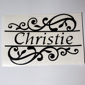 May include: Black vinyl decal with a decorative scroll design and the name "Christie" in a cursive font.