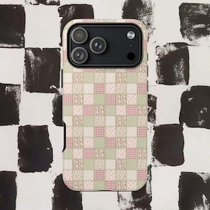 Peut inclure: Une coque de smartphone arborant un motif en damier façon patchwork. Le design se compose de carrés alternés dans des tons doux de vert sauge, rose pâle et crème, ornés de minuscules imprimés floraux, de petits pois et de carreaux vichy.