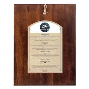 May include: A wooden plaque with a certificate of authenticity for a Byzantine icon. The certificate is written in Greek, English, and Russian. The plaque is decorated with a dove and the words "Blessed Gifts".