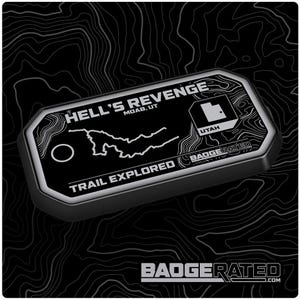 Op de afbeelding: Zwart-witte trailbadge met de tekst "Hell's Revenge Moab, UT" en "Trail Explored" met een kaart van de trail en een omtrek van de staat Utah. De badge is gemarkeerd met "BadgeRated".