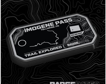 May include: A black and white badge with the text "Imogene Pass Telluride, CO" and "Trail Explored" with a map of the area and a small Colorado flag. The badge is labeled "Badgrated.com".