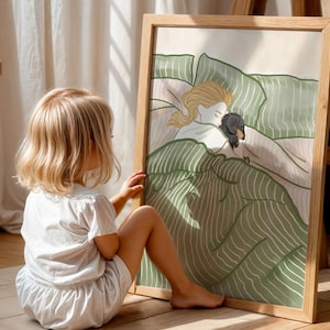 May include: A framed art print featuring a whimsical illustration of a person and a dachshund dog sleeping under green and white striped bedding. The artwork is in a wooden frame. A young child is sitting on the floor, looking at the artwork.