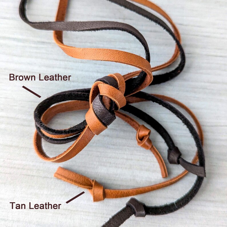 May include: Close-up of three leather cords, one black, one brown, and one tan. The cords are tied together in a knot. The text "Brown Leather" and "Tan Leather" are written on the image.
