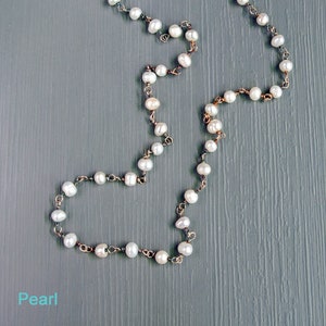 May include: A pearl necklace with a silver chain. The pearls are white and round.