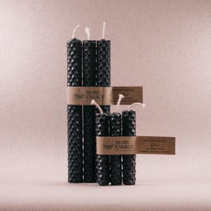 Puede incluir: Conjunto de velas de cera de abeja negra con etiquetas que dicen "More Energy Grow Yourself" y "100% cera de abeja pura Negra"