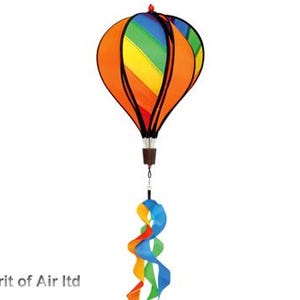 May include: A vibrant hot air balloon wind spinner featuring orange, yellow, green, and blue panels. The balloon has a brown basket and black detailing. Swirling, colourful ribbons hang below.