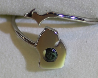 Anillo de plata de ley con forma de Michigan en la parte superior e inferior, banda de 1 mm. La gema es piedra verde de Michigan pulida, clorastrolita, la gema del estado de Michigan.