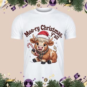 May include: White t-shirt featuring a cartoon cow wearing a Santa hat and a plaid scarf, holding a candy cane. The text "Moo-ry Christmas, y'all" is printed above the cow. Festive holiday apparel.