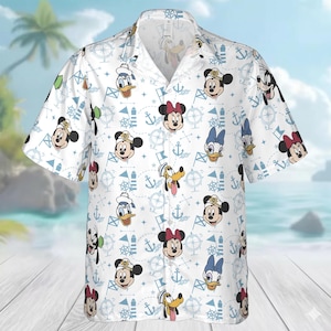 May include: White button-up shirt featuring a nautical-themed pattern with cartoon characters. The design includes Mickey Mouse, Minnie Mouse, Donald Duck, and Goofy, along with anchors, flags, and compasses. The shirt has short sleeves and a classic collar.