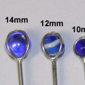 May include: Four glass marbles on silver sticks, with diameters of 14mm, 12mm, 10mm, and 8mm. The marbles are blue, white and blue, blue, and green.