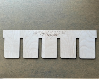 May include: A wooden sign with five slots, labeled "SCOTT SWEET Designs".