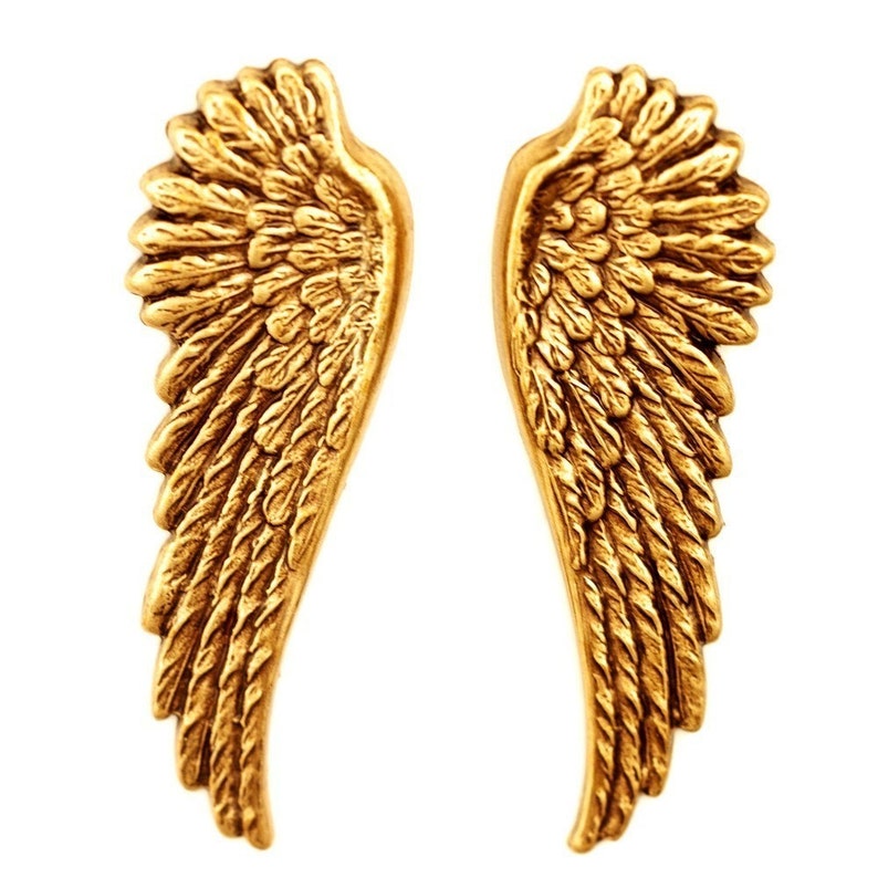 Pode incluir: Um par de brincos de asa de anjo em tom dourado. As asas s&atilde;o detalhadas com um design de pena texturizado.