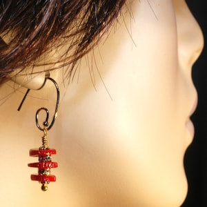 May include: Gold dangle earrings with a stack of red and gold beads. The beads are accented with small clear rhinestones.