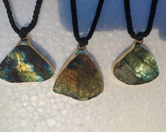 May include: Three gold necklaces with iridescent labradorite stone pendants. The stones are a mix of green, blue, and gold.