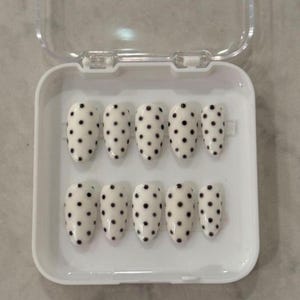 Jeu d'ongles blancs et noirs à pois