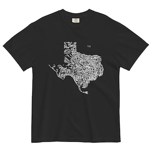 May include: Black t-shirt with a white outline of the state of Texas, including the rivers and streams. The text "TX" is printed above the state outline.