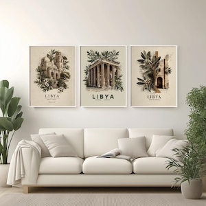 Może przedstawiać: Trzy oprawione wydruki artystyczne z ilustracjami architektonicznymi Libii. Każdy wydruk ma białą obwódkę i przedstawia inną historyczną strukturę, z napisem "LIBIA" i "PÓŁNOCNA AFRYKA" poniżej. Wydruki są eksponowane nad białą sofą.