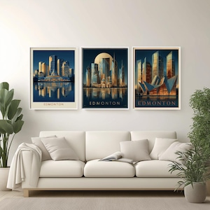 Pode incluir: Três impressões artísticas emolduradas com paisagens urbanas estilizadas de Edmonton. Cada impressão mostra uma perspectiva diferente do horizonte da cidade, com edifícios em tons de azul, dourado e laranja. A palavra "EDMONTON" é impressa na parte inferior de cada moldura.