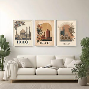 Peut inclure: Trois impressions d'art encadrées représentant des monuments irakiens. Chaque impression présente une scène architecturale différente avec des accents floraux et le mot "IRAQ" en bas. Les impressions sont dans des tons neutres et sont affichées au-dessus d'un canapé blanc.