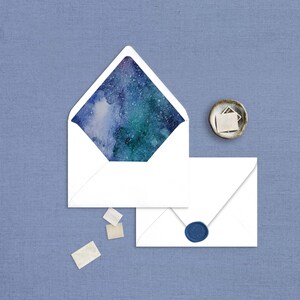 May include: A white envelope with a blue and green watercolour galaxy design on the inside flap. The envelope is sealed with a blue wax seal.