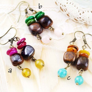 May include: Three pairs of earrings with brown square beads, different colored round beads, and gold-toned metal hooks. The earrings are labeled 'a', 'b', and 'c'.