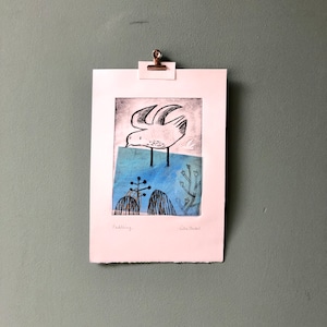 May include: A black and white print of a bird with its wings spread, standing on a blue and white background. The print is titled "Paddling" and signed "Lisa Stickler".