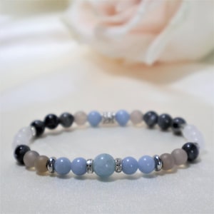 May include: A light blue gemstone bracelet with silver beads and a mix of gray, white, and brown beads.