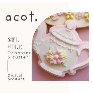 Może przedstawiać: Różowe i białe ciastko w kształcie czajniczka z kwiatowym wzorem. Ciastko jest ozdobione różowym, żółtym i białym kwiatem. Obraz zawiera również tekst "acot.", "STL FILE", "Debosser & cutter" i "Digital product".