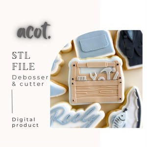Può includere: Biscotti decorati con glassa azzurra e beige. Un biscotto ha la forma di una cassetta degli attrezzi con attrezzi. Altri biscotti hanno la forma di una giacca, un portafoglio, un pesce e la parola "Reely". È presente anche il testo "STL FILE Debosser & cutter Digital product".
