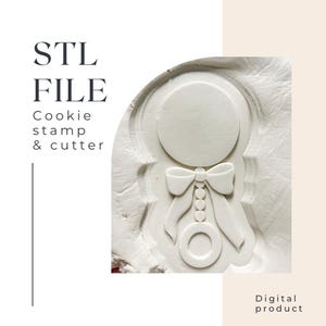 Op de afbeelding: STL-bestand Cookie stempel & -snijder voor het maken van een baby-ratelkoekje. Het ontwerp is een wit silhouet van een rammelaar met een strik en kralen op een witte achtergrond.