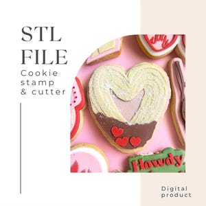 Może przedstawiać: Cyfrowy plik STL do wykrawaczki do ciasteczek i stempla w kształcie serca z mniejszym sercem w środku. Serce jest ozdobione czerwonym i brązowym lukrem. Tekst "Howdy" jest widoczny na zielonym ciasteczku w tle. Produkt cyfrowy.