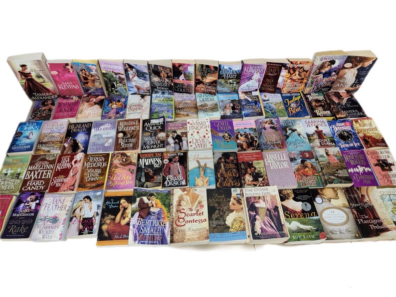 Peut inclure: Une collection de romans d'amour en format poche avec diff&eacute;rents titres et auteurs. Les livres sont dispos&eacute;s en rang&eacute;es et pr&eacute;sentent une vari&eacute;t&eacute; de couvertures avec des couleurs et des motifs diff&eacute;rents.