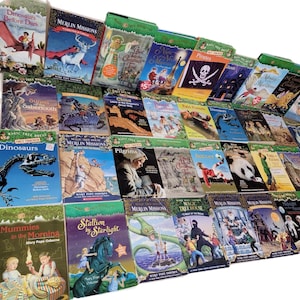 May include: A collection of Magic Tree House books with various titles, including "Dinosaurs Before Dark", "Merlin Missions", "Mummies in the Morning", and "Stallion by Starlight". The books are arranged in a row, with the spines facing the viewer. The books are all green and have a similar design.