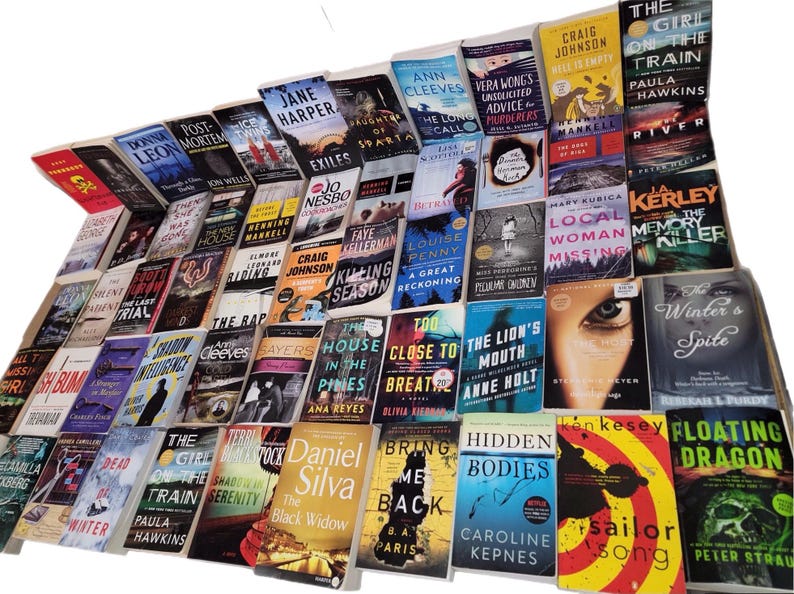 May include: A large collection of paperback books, mostly mystery and thriller novels, with various titles and authors. The books are stacked in a pyramid shape, with the titles facing outward.
